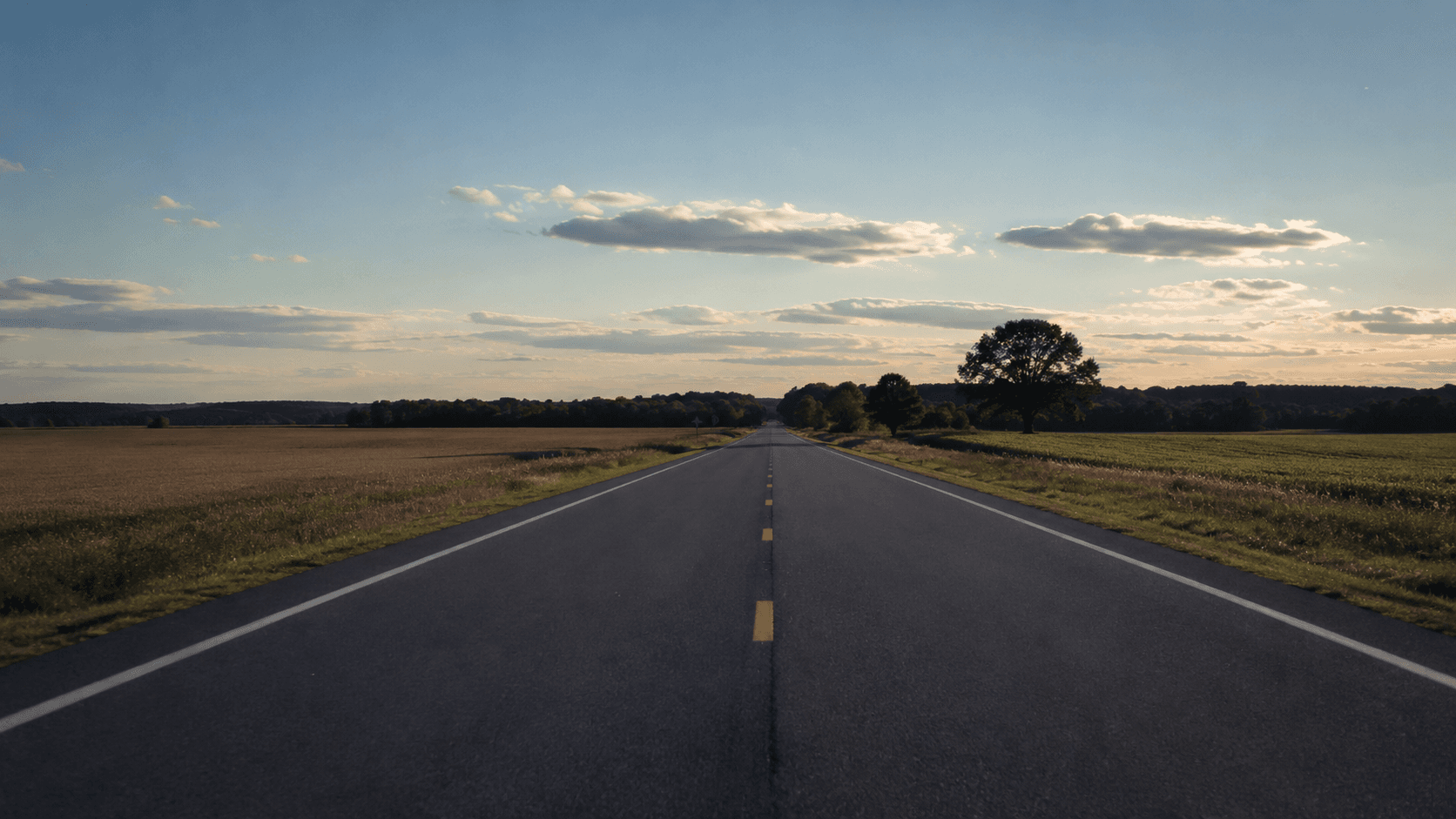 An empty two-lane rural highway through Suffolk, Virginia farmland
