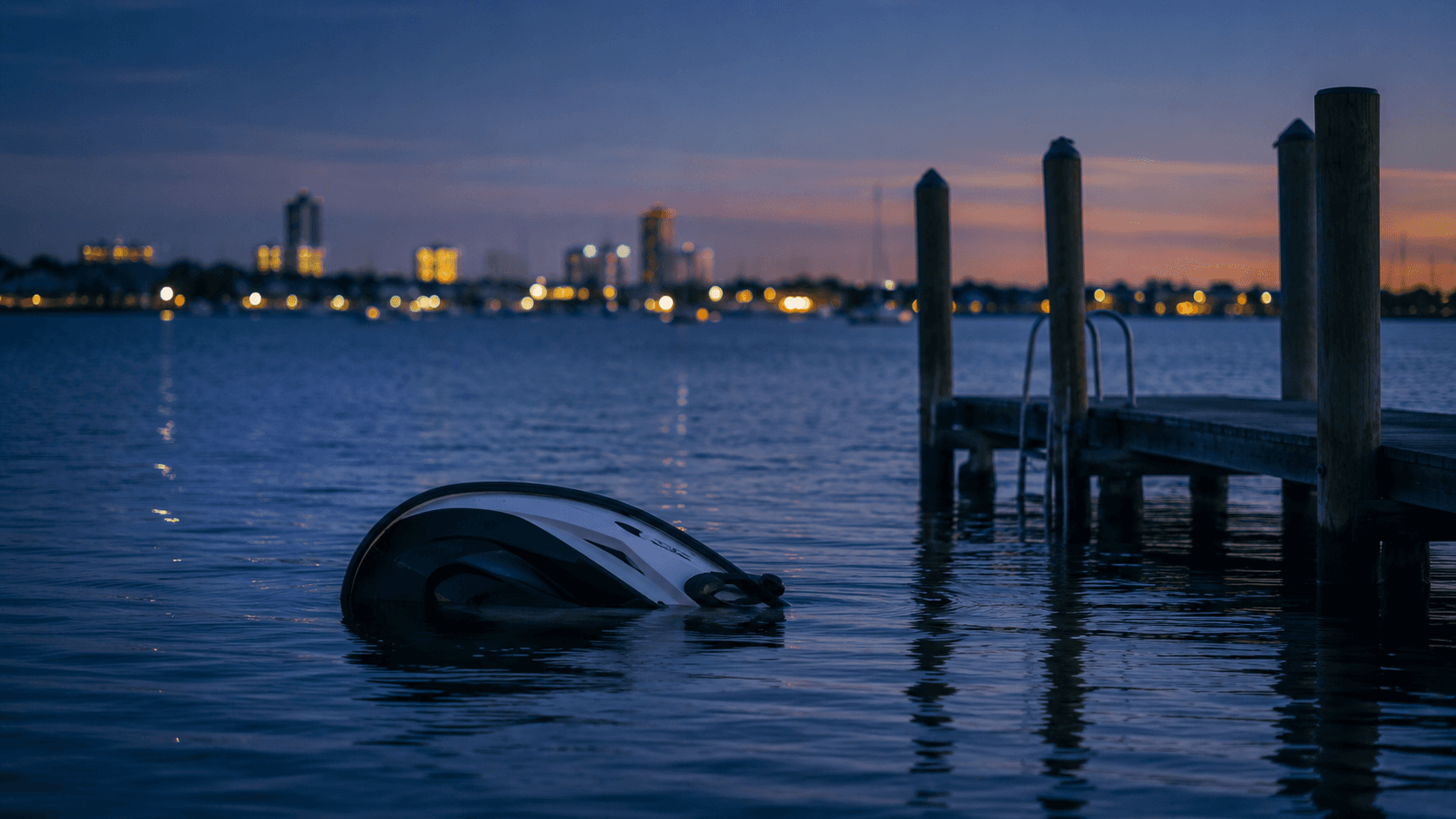 An overturned personal watercraft near a Chesapeake Bay dock at dusk