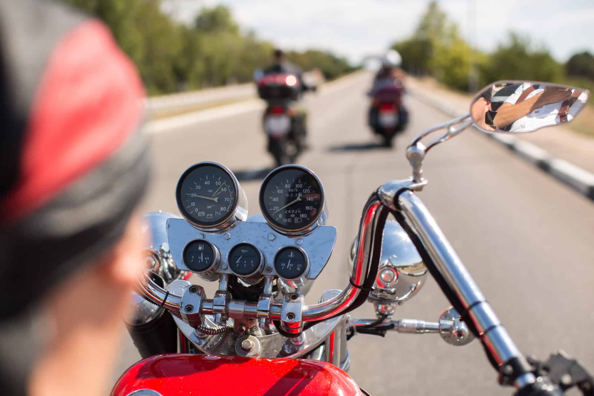 Biker riding motorcycle on road in morning sunny day Shot from behind